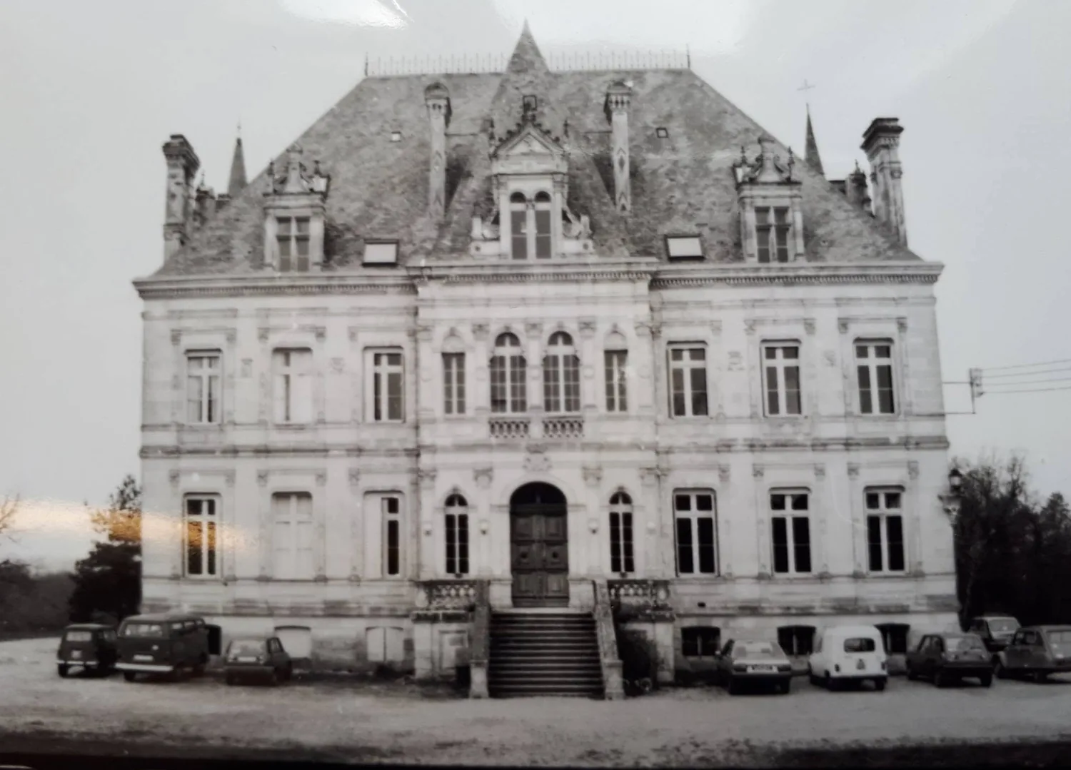 The château in an early photograph, period cars in front of the steps