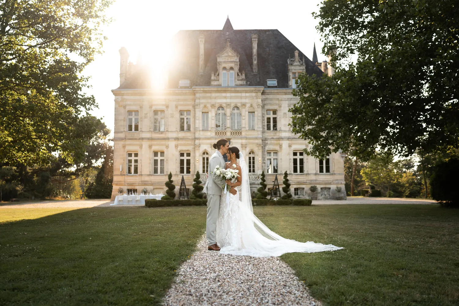 A married couple in front of the château, backlit
