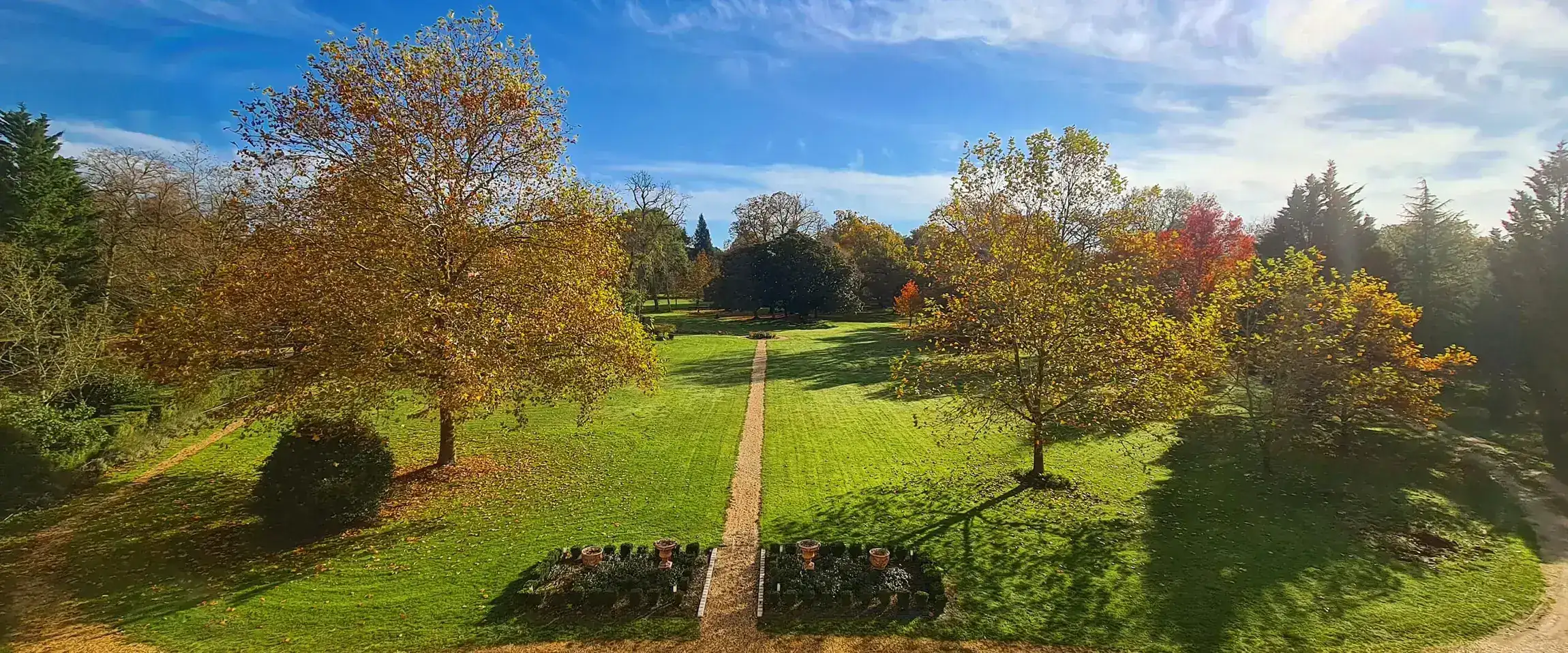 The long perspective of the park, the mown axis and the autumn trees