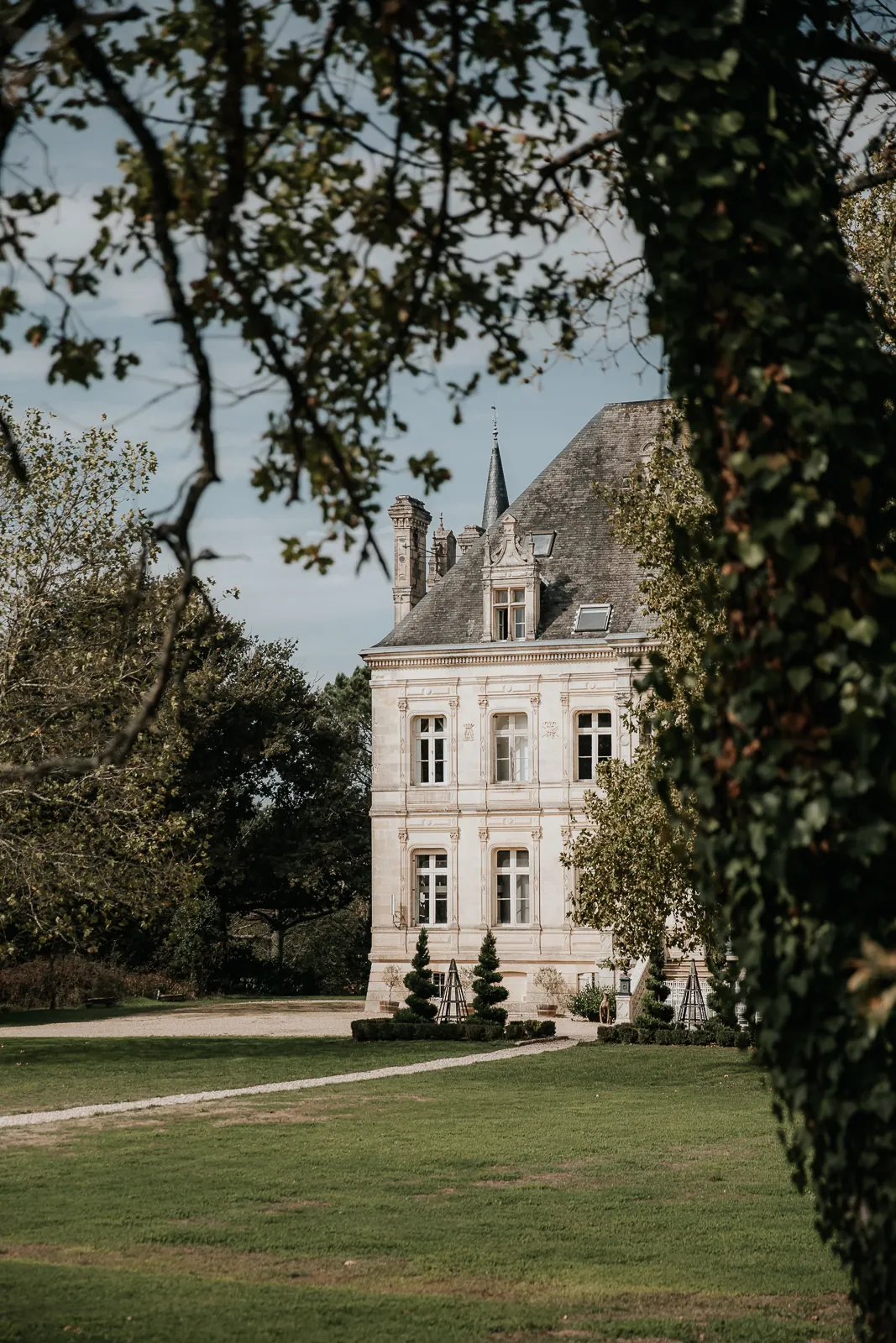 The château glimpsed between the trees