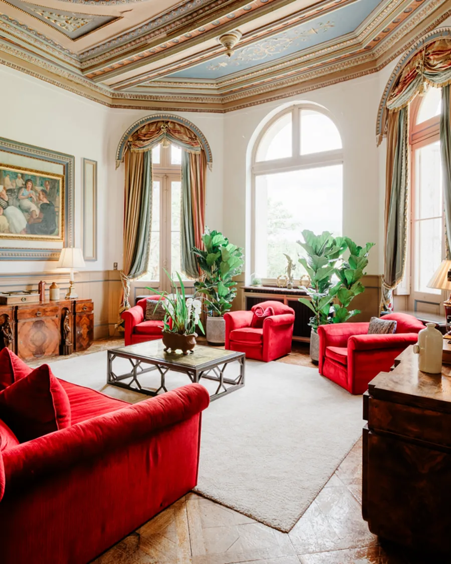 The grand salon, red sofas under a blue ceiling
