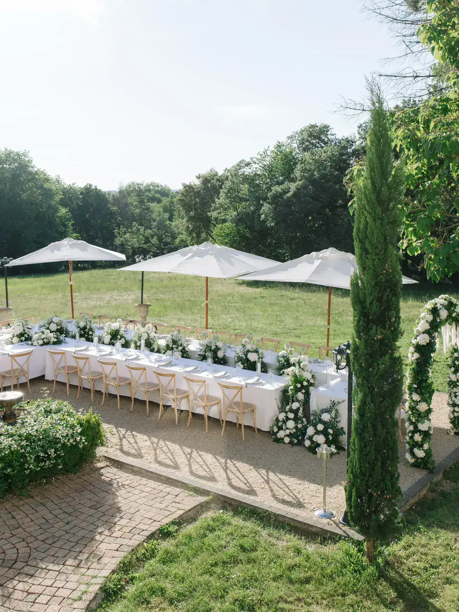 The long table laid under parasols on the back terrace