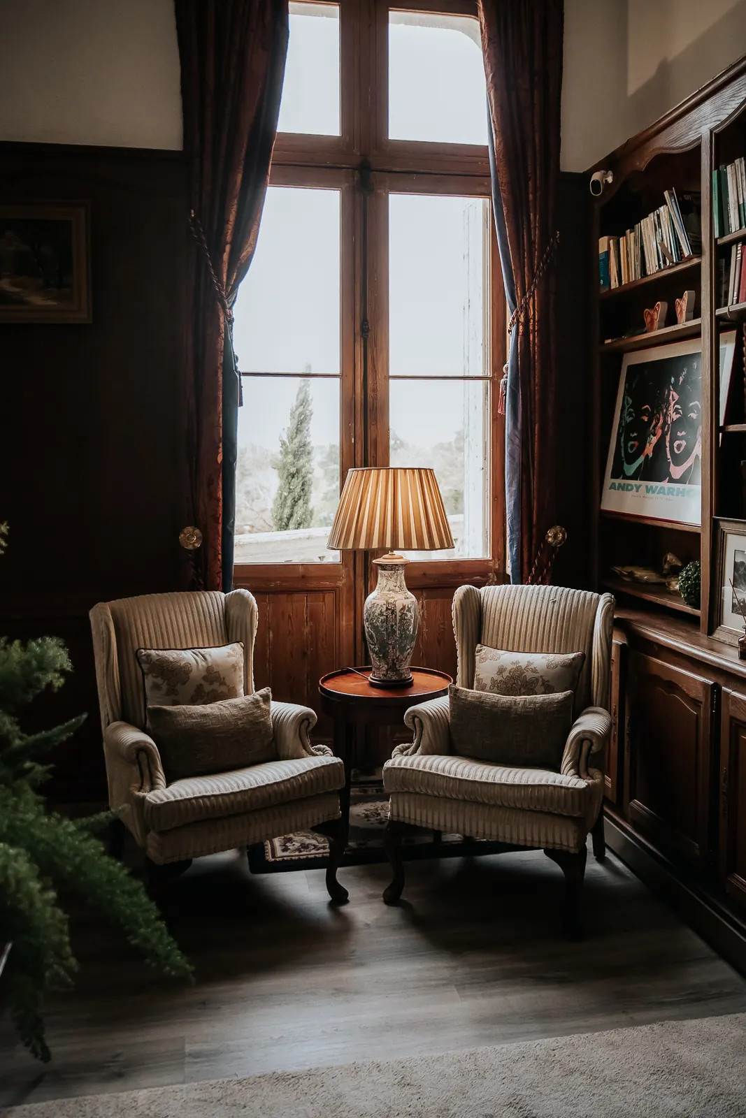 The seating corner of the library, armchairs and lamp