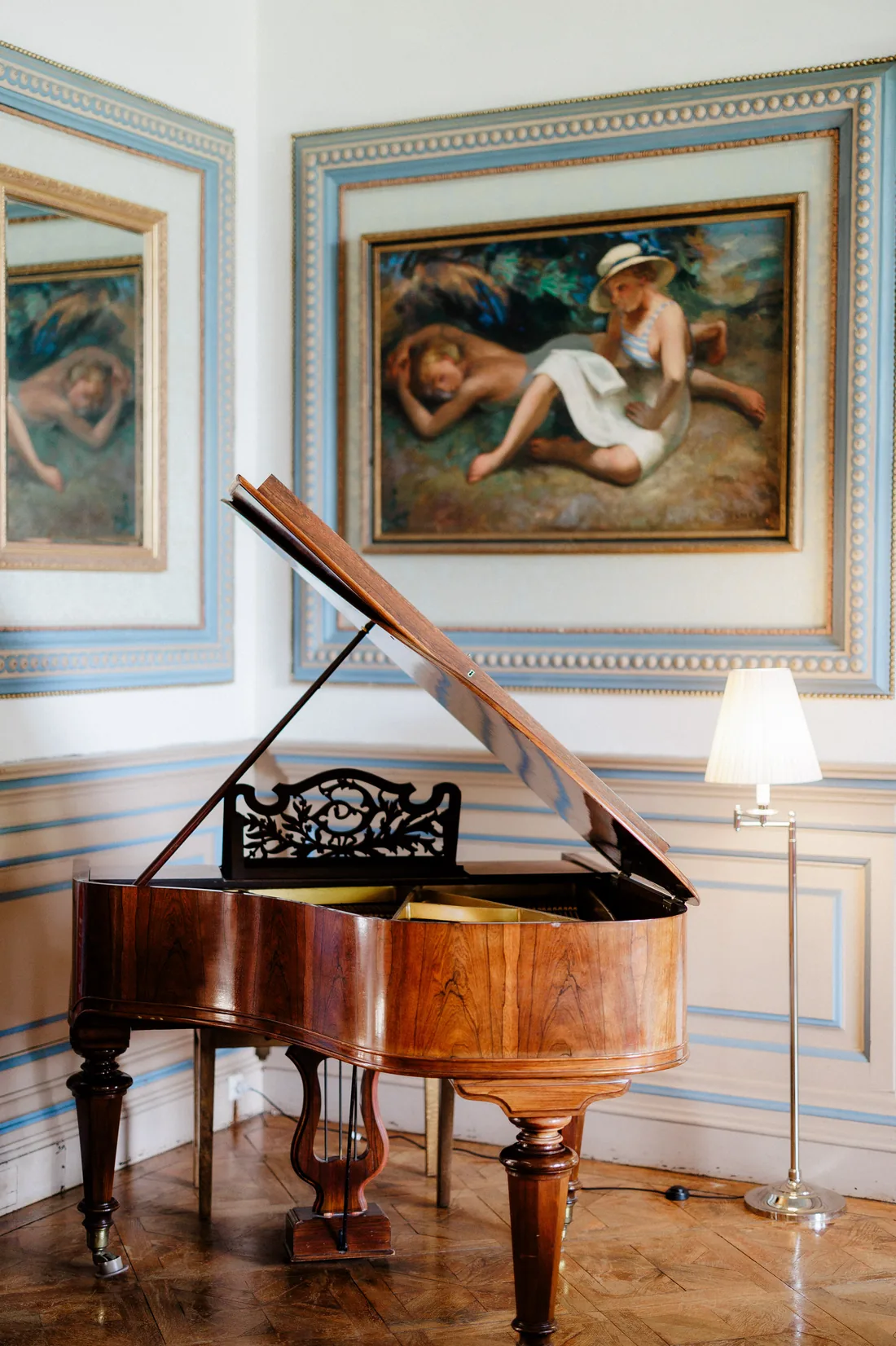 The baby grand piano and the paintings in the salon