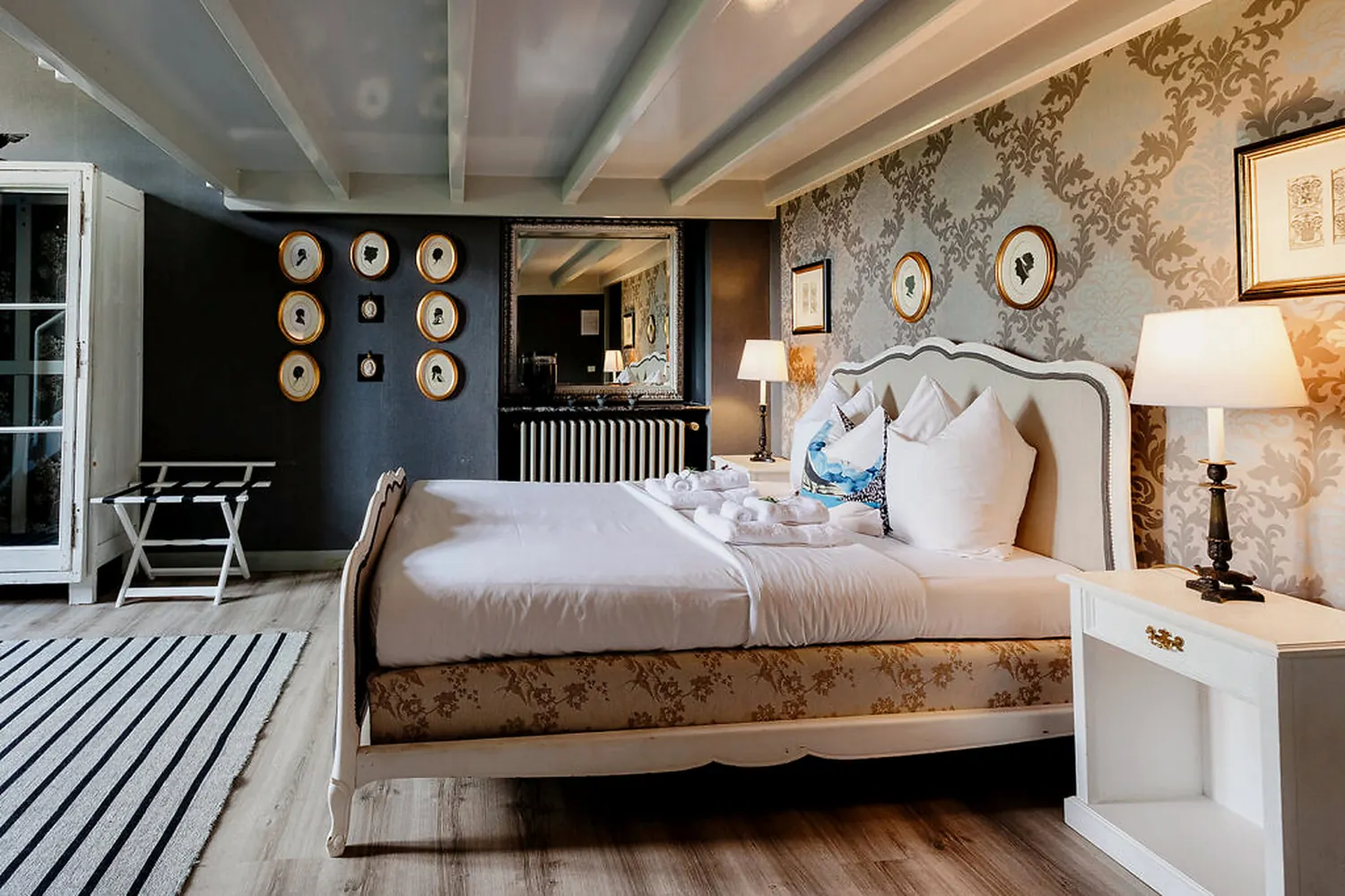 A bedroom with chinoiserie wallpaper and an upholstered bed