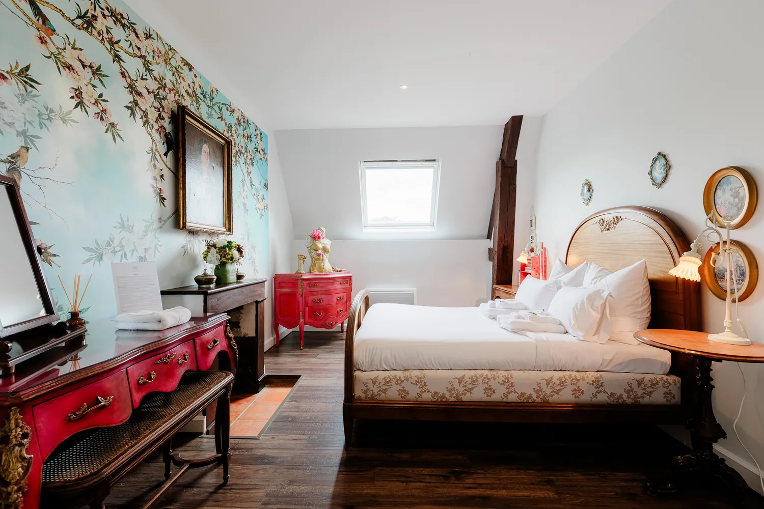 The Eugénie bedroom, its blossom wallpaper and red lacquer desk