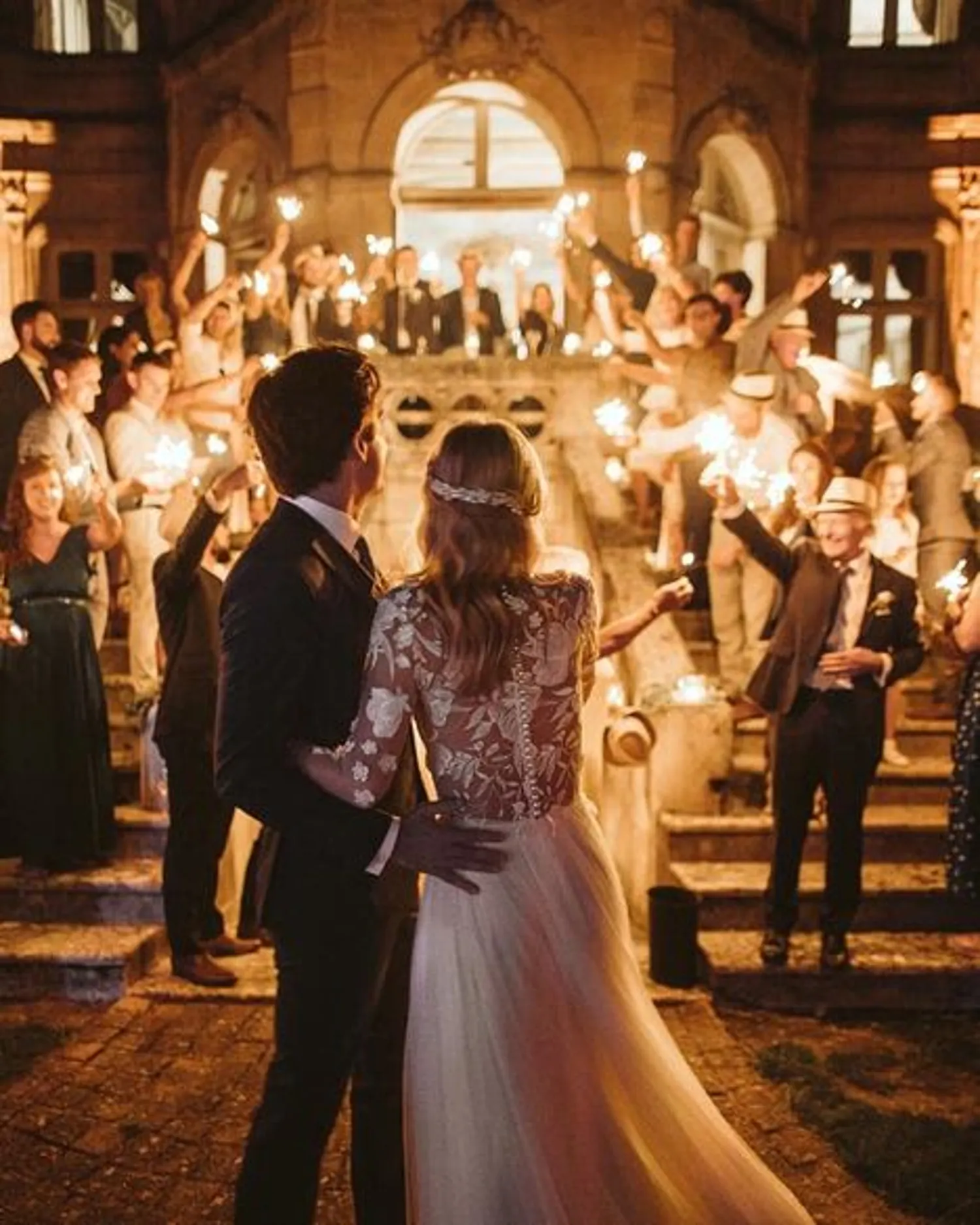 The couple entering the hall between sparklers