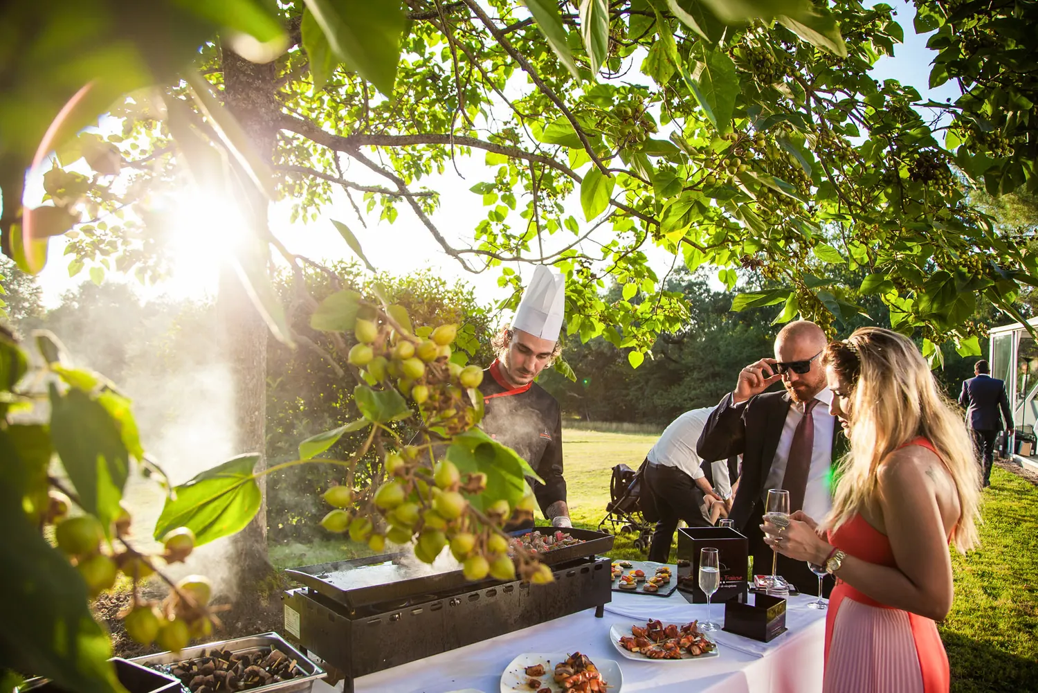 The buffet in golden backlight, the chef and the guests