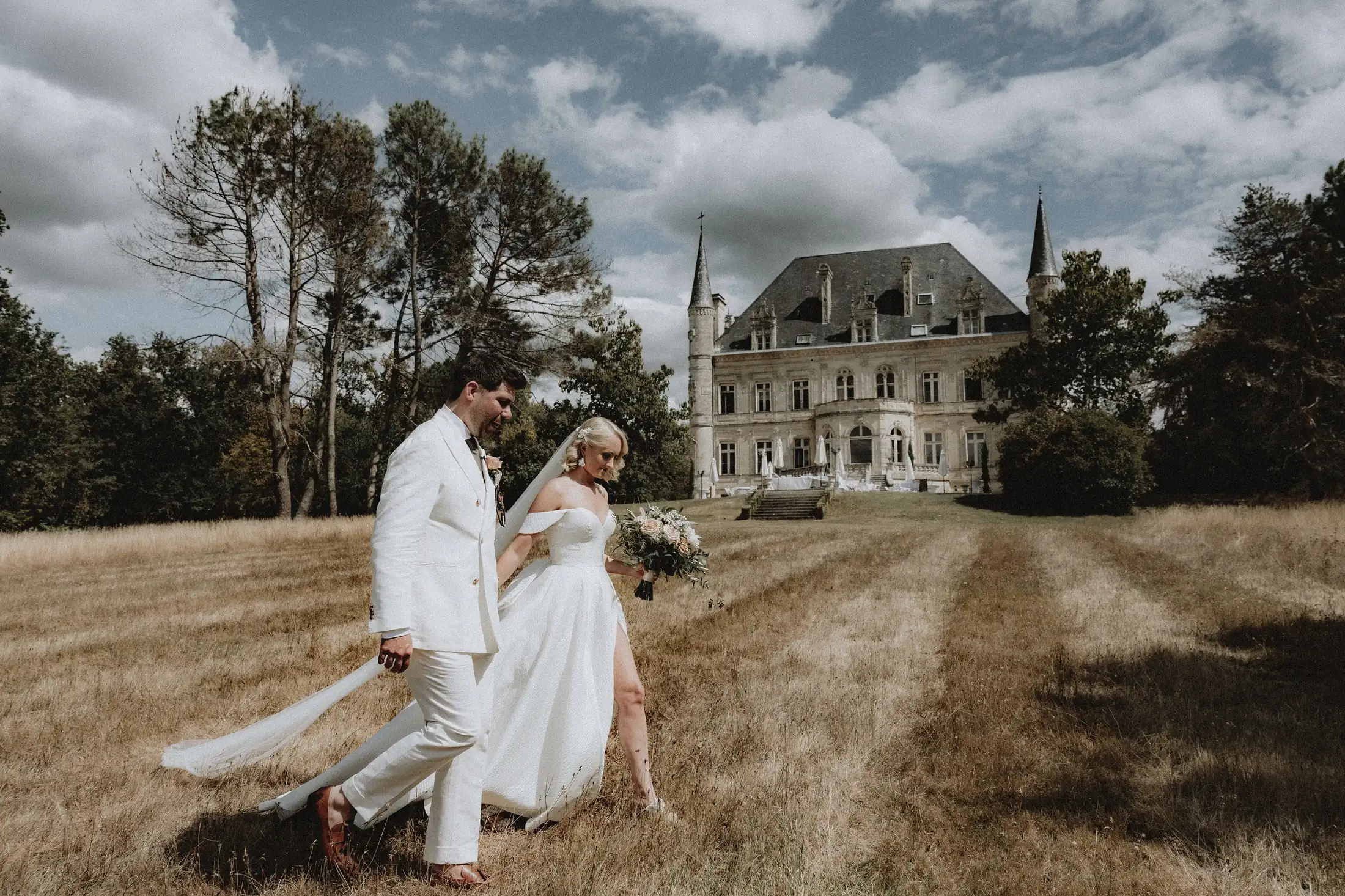 A married couple in the field under a storm sky